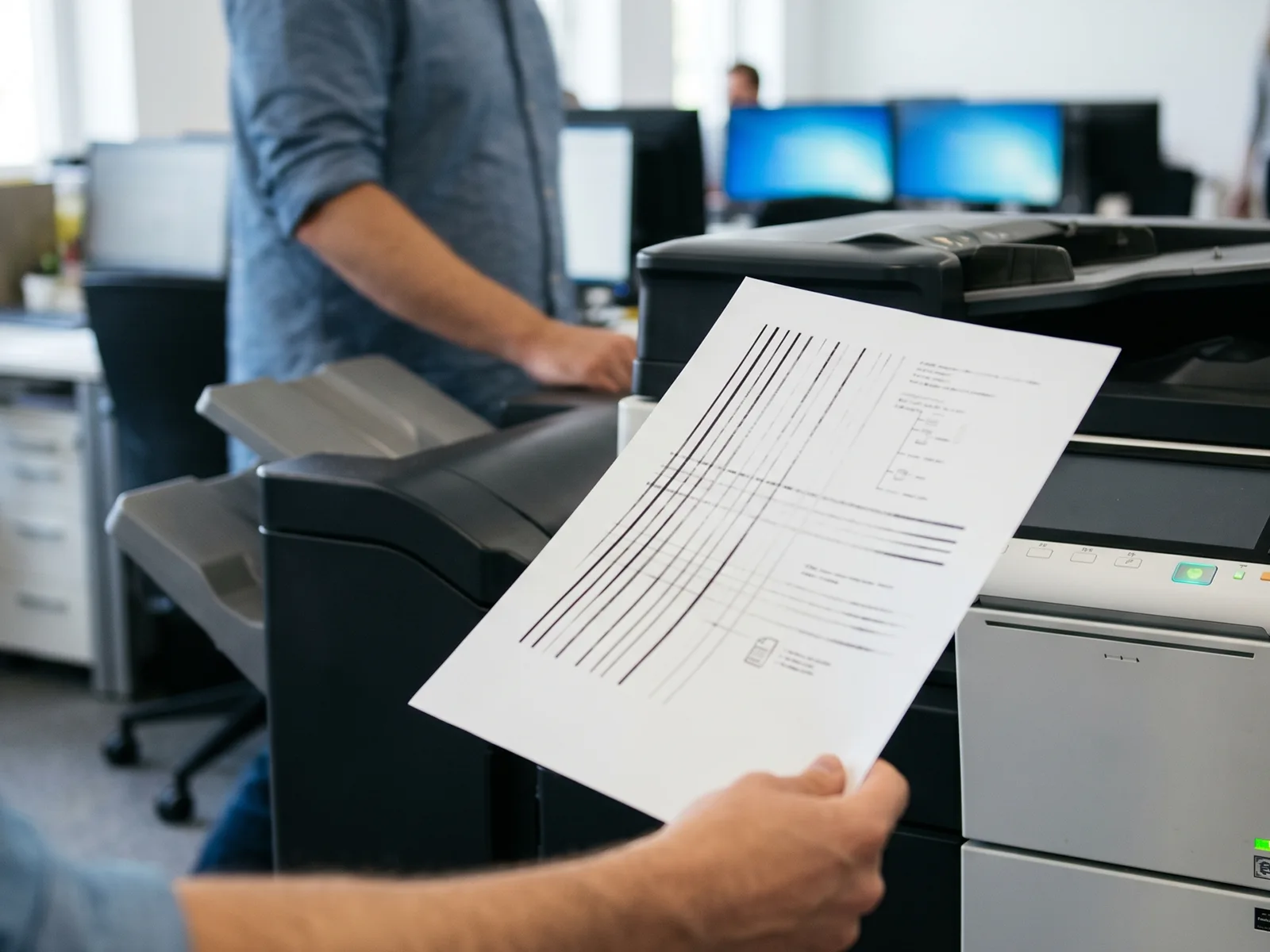 Office worker inspecting a printout with faded lines from a laser copier